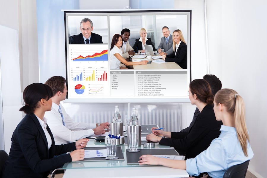 A virtual meeting takes place in a conference room.