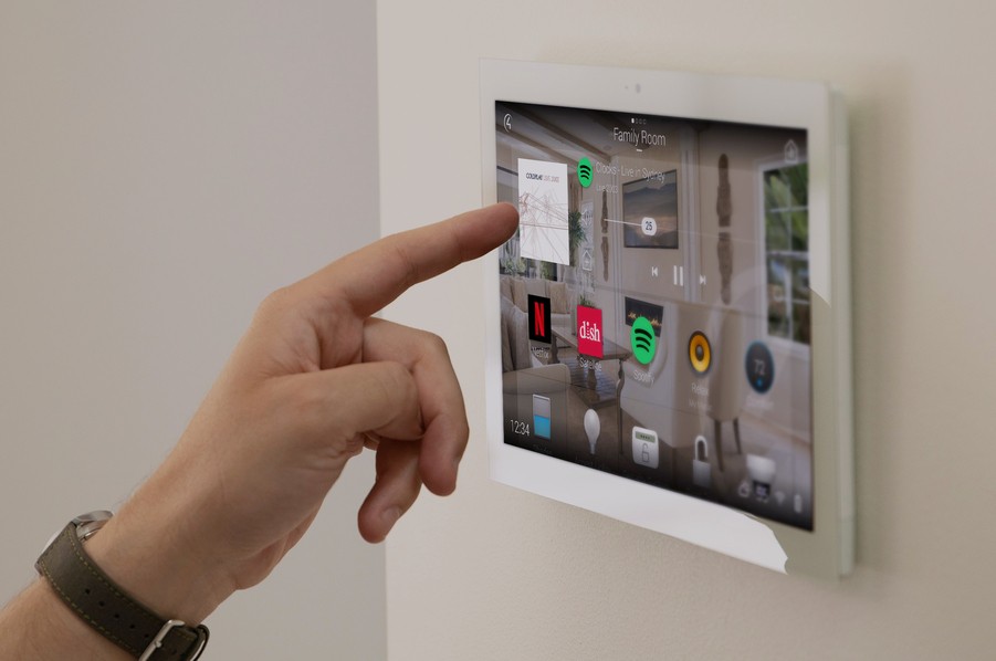 Closeup of a person using a wall-mounted Control4 interface. 