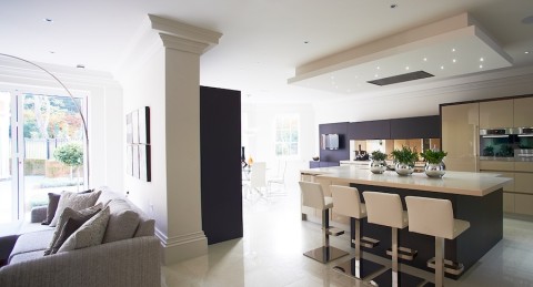 Modern open concept kitchen and living area with sleek design and automated lighting.