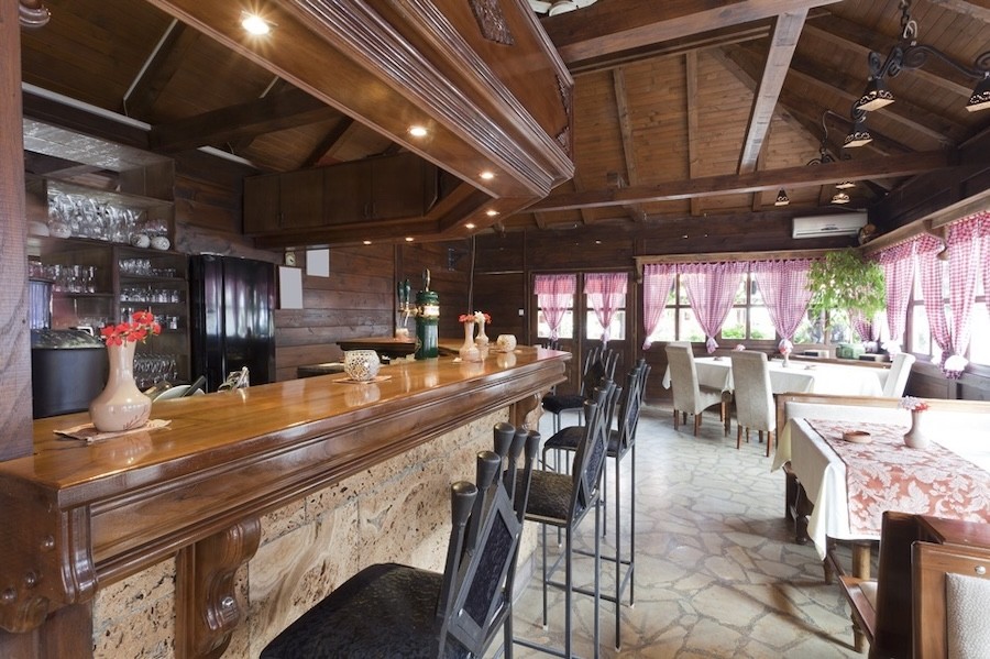 restaurant’s bar area with wood grain finishes on bartop and ceiling.